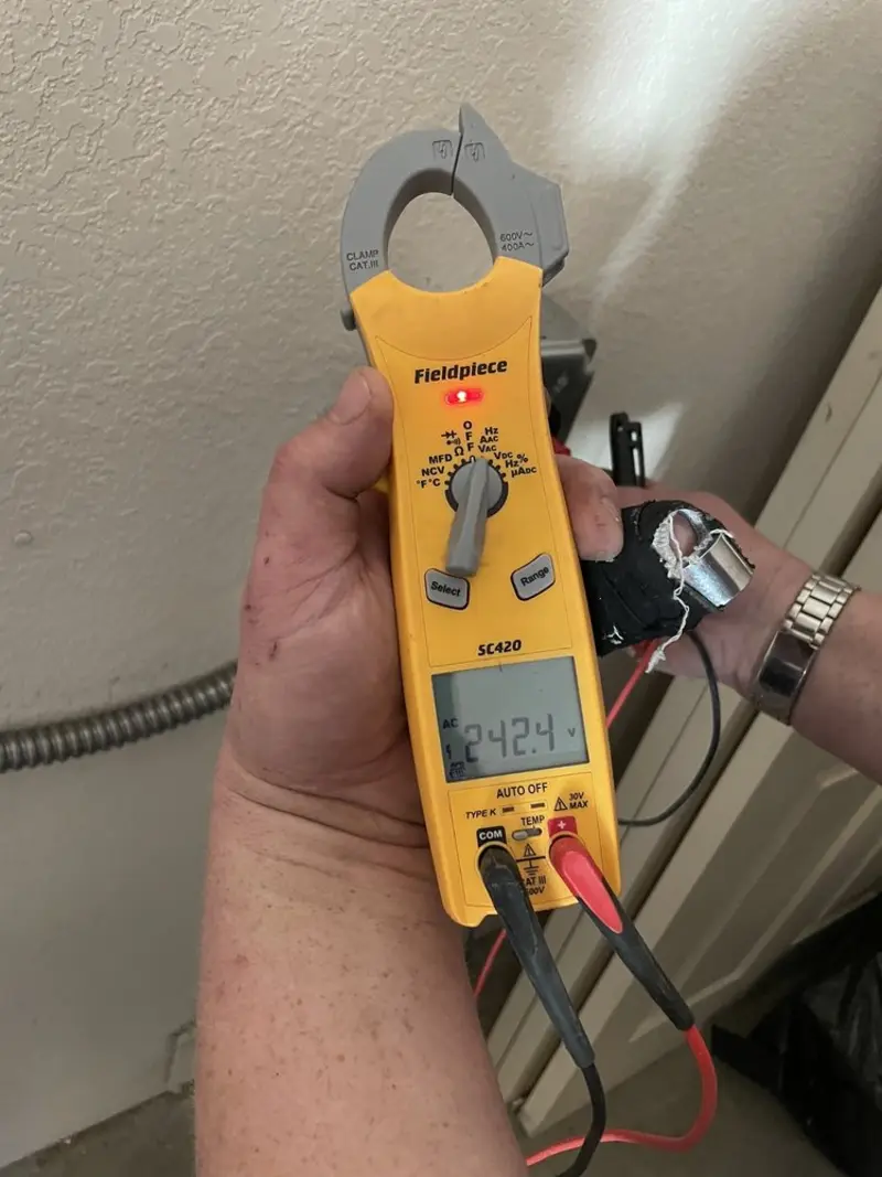 Voltage testing with clamp meter during Whole House Surge Protector in Whitefish Bay